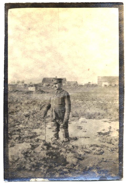 Photograph of Captain Robert Patrick Neville standing in the mud (NRO 06038/16)